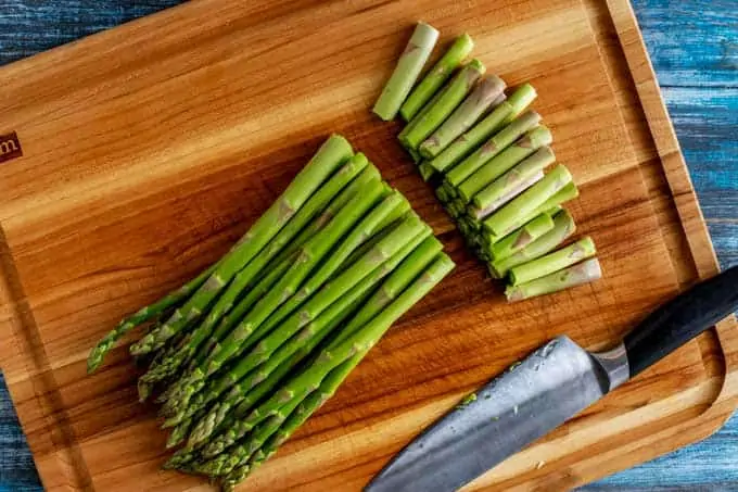 Photo of asparagus on a cutting board with the ends trimmed off.