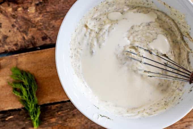 Photo of Keto Ranch Dressing being thinned with additional cream.
