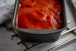 Photo of meatloaf with the sauce on it ready to go back into the oven.