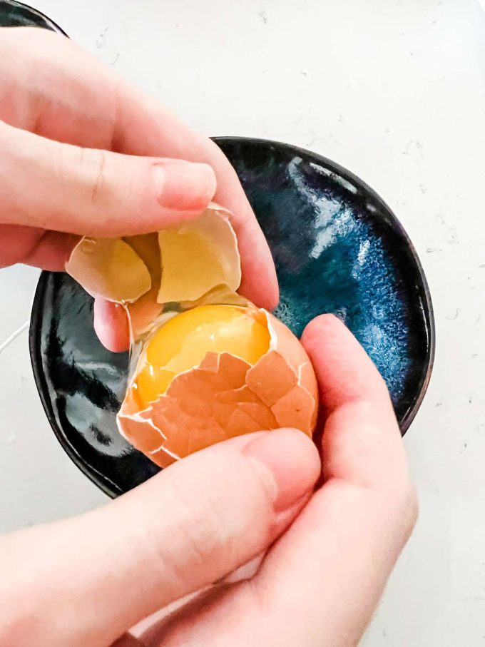Photo of an egg being cracked and seperated.