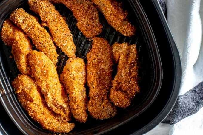 Photo of breaded chicken fingers in an air fryer.