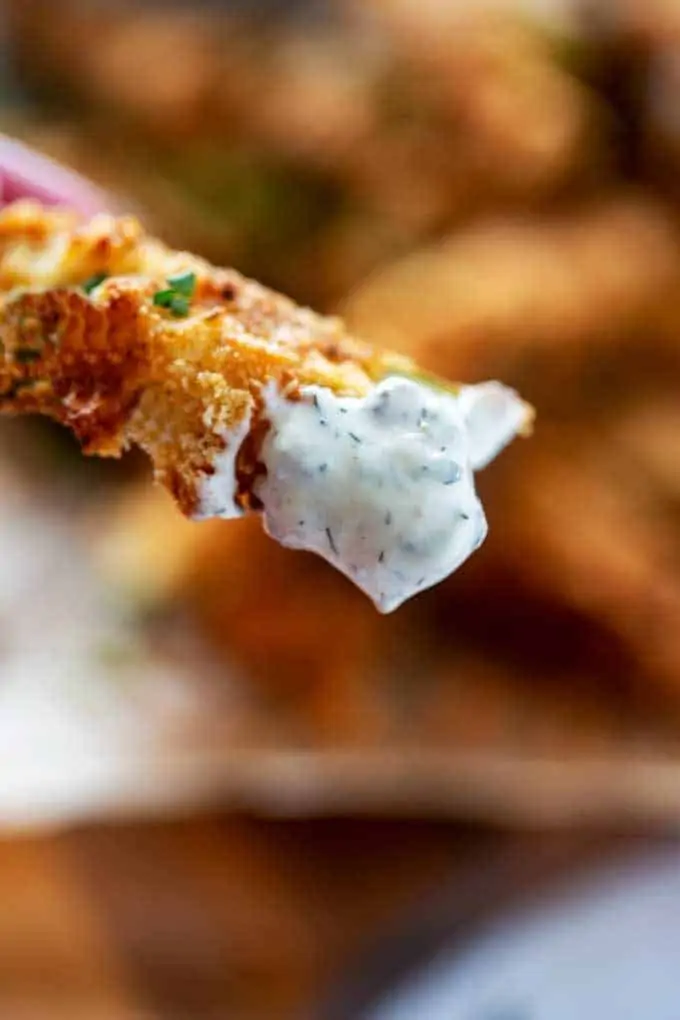 Close up photo of a Keto Fried Pickle that has been dipped in ranch dressing.