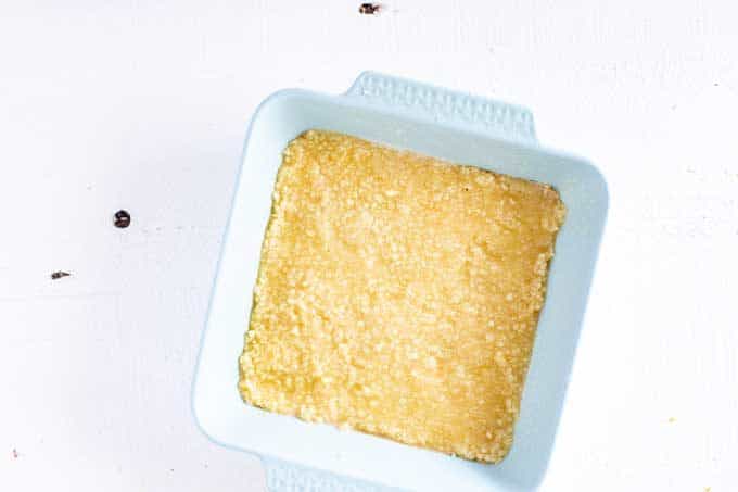 Photo of a macadamia nut crust in a pale blue baking dish.