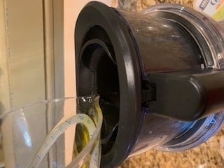 Photo of oil being added to the chute of a food processor.