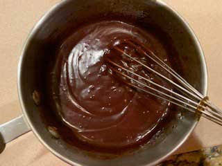 Photo of chocolate being melted in a saucepan with heavy cream, brown sugar substitute and salt.