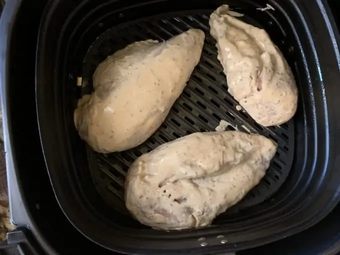 Photo of chicken that has just been added to an air fryer.