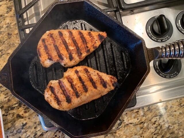 Photo of chicken in a cast iron grill pan.