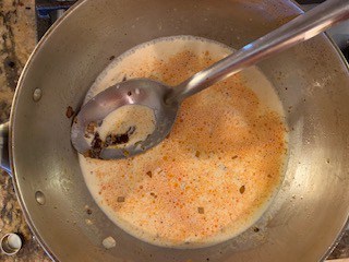 Photo of onion, chipotle chili, xanthan gum, heavy cream, and chipotle sauce in a sauce pan.