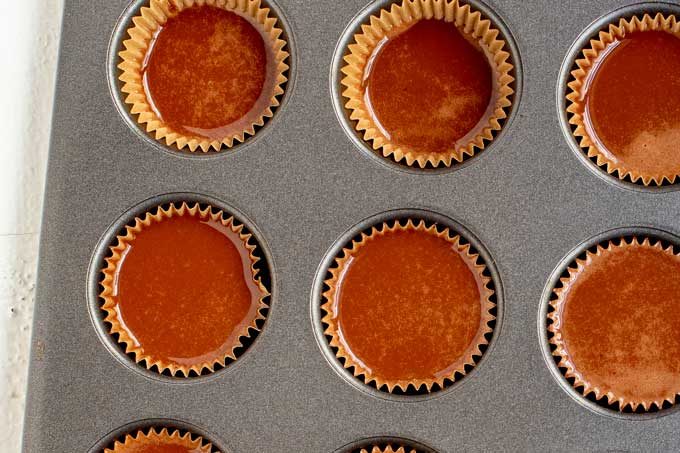 Photo of a mini muffin tin with chocolate keto fat bombs ready to go in the freezer.