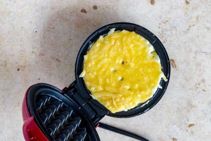 Photo of a chaffle cooking in a dash mini-waffle iron.