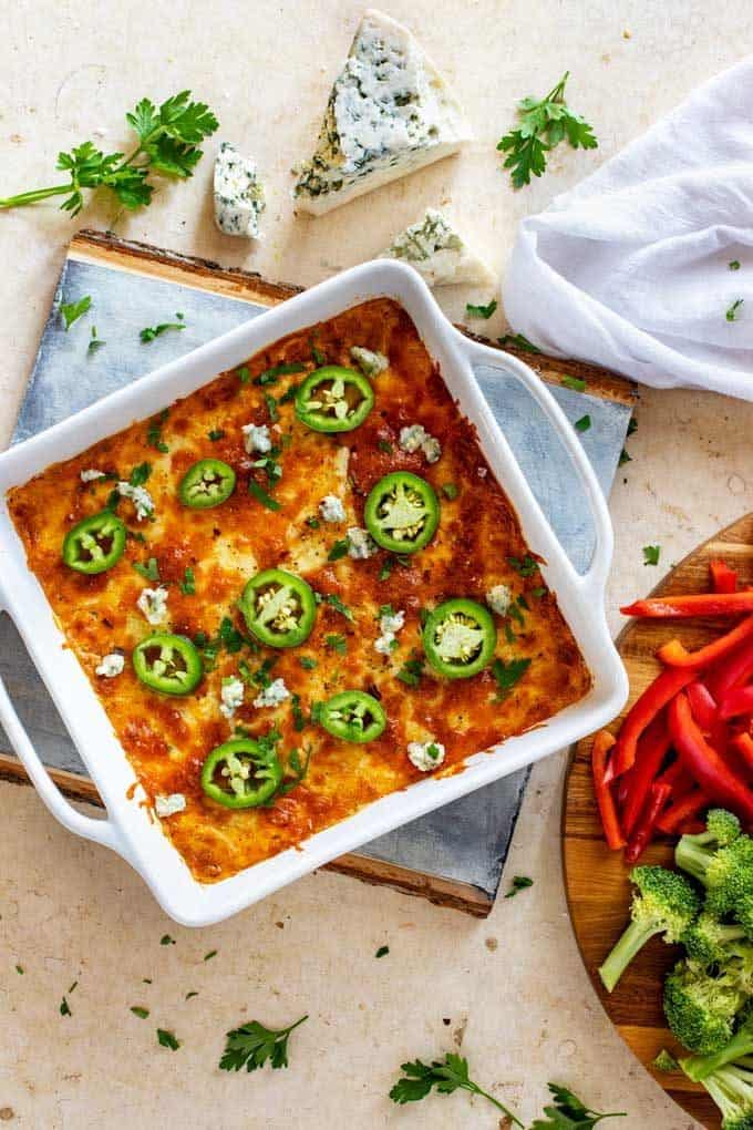 Overhead photo of a white casserole dish with low carb buffalo chicken dip in it garnished with jalapenos.