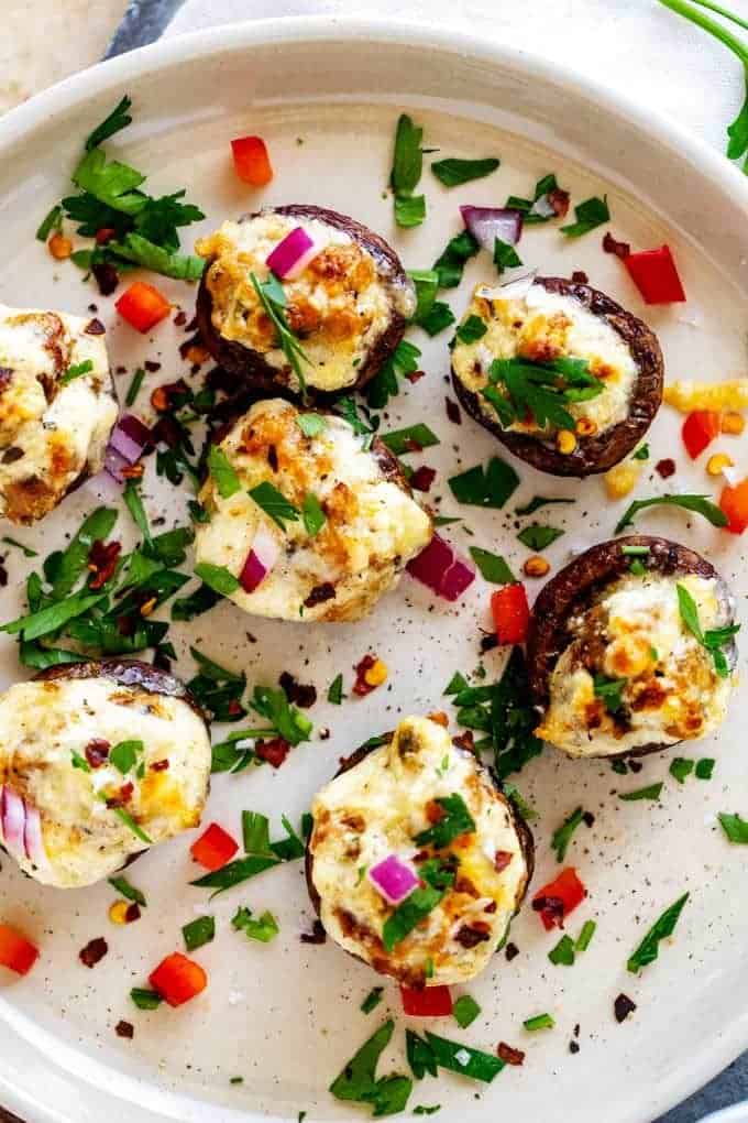 Close up photo of a plate of Keto Stuffed Mushrooms garnished with parsley.