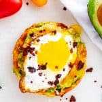 Square overhead photo of Keto Avocado Toast with melted cheese, fried egg, and crumbled bacon.