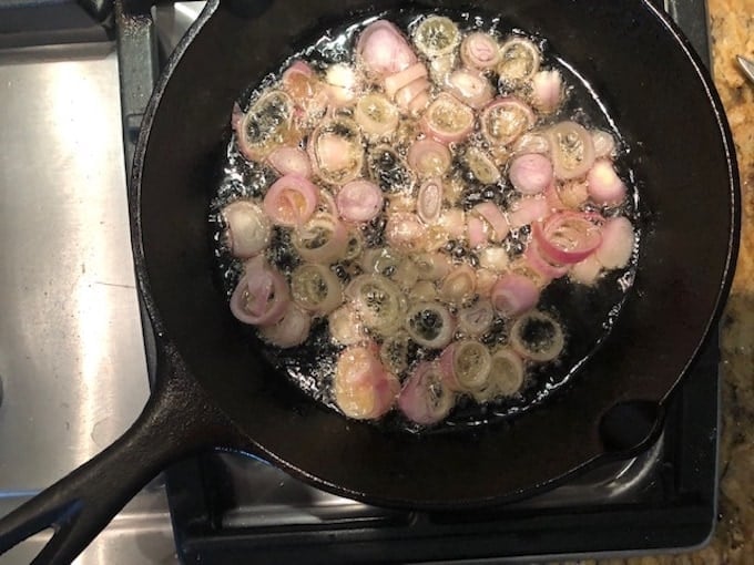 Shallots frying in a small skillet.
