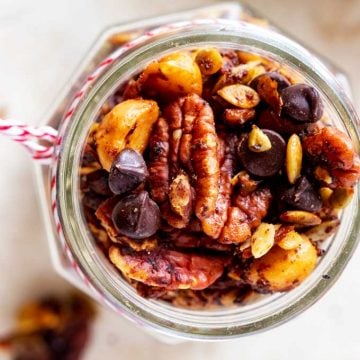 Overhead photo of Keto Trail Mix in a glass jar with a red and white string around it.