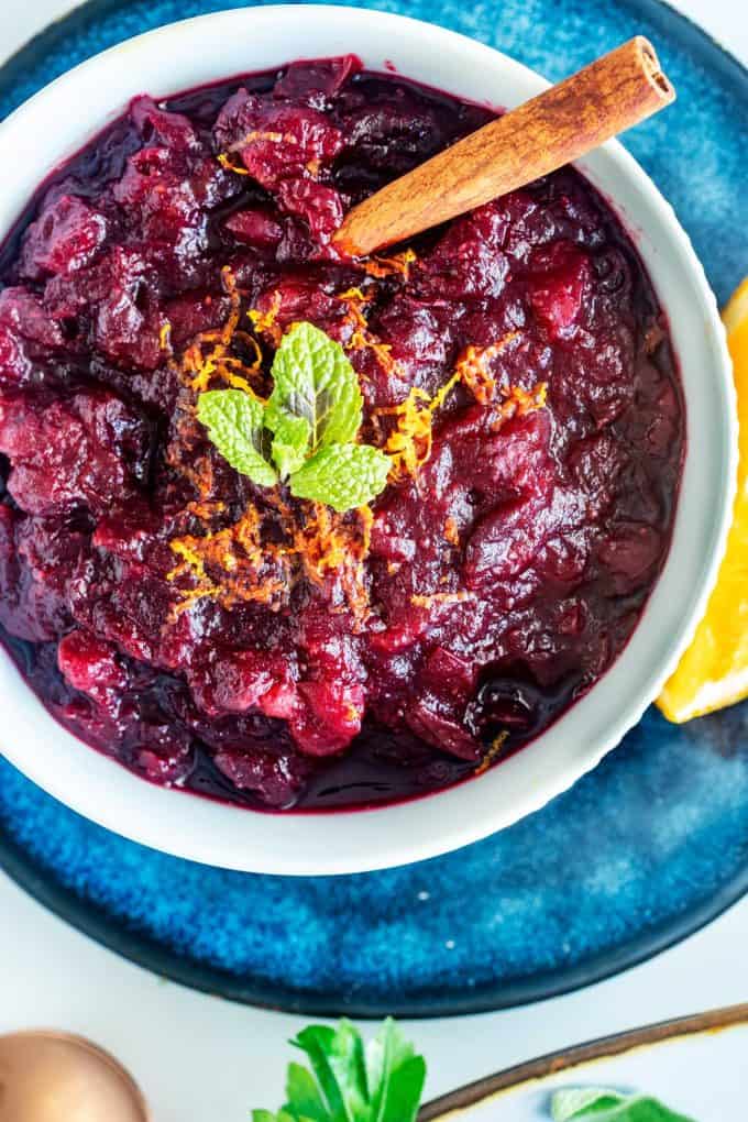 Overhead photo of keto cranberry sauce in a bowl sitting on a blue platter.