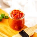Square close up photo of a small glass jar with keto BBQ Sauce.