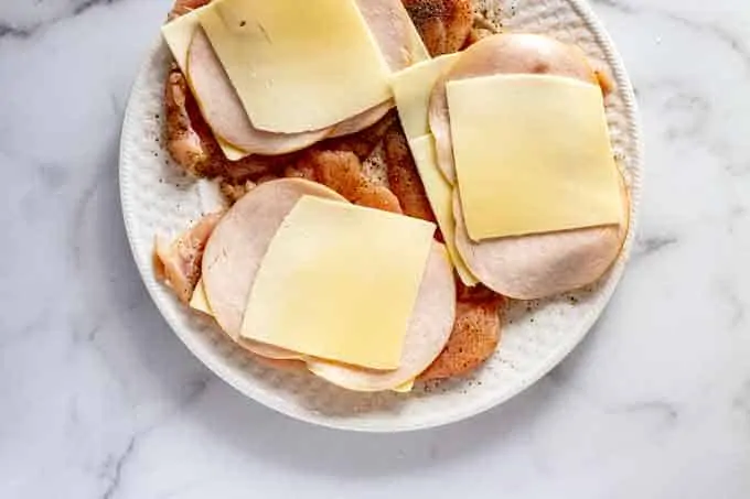 Photo of chicken topped with cheese and ham or turkey.