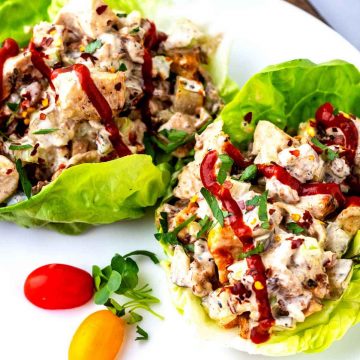Close up square photo of Keto Chicken Salad in lettuce wraps drizzled with sriracha.