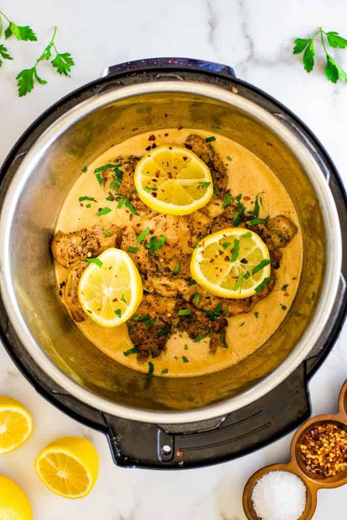 Overhead photo of lemon chicken in an Instant Pot against a white background.