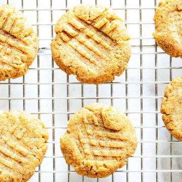 Square overhead photo of keto peanut butter cookies on a cooling rack against a white background.