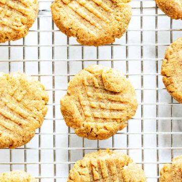 Overhead photo of keto peanut butter cookies on a cooling rack against a white background.
