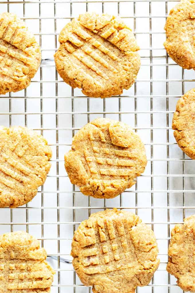 Overhead photo of keto peanut butter cookies on a cooling rack against a white background.