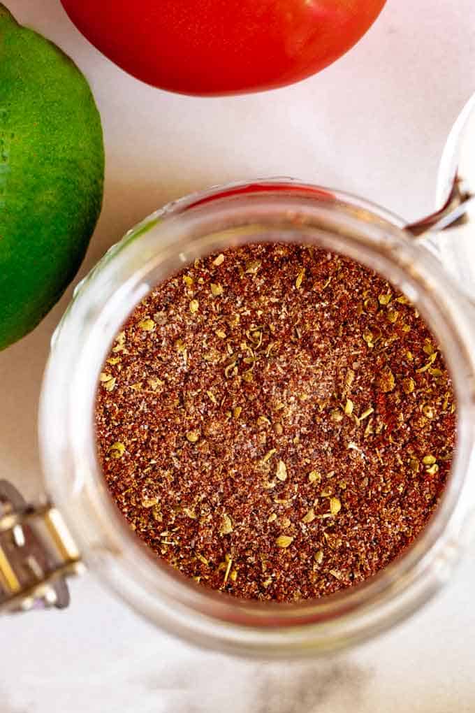 Close up photo of Keto Taco Seasoning in a jar on a white background.