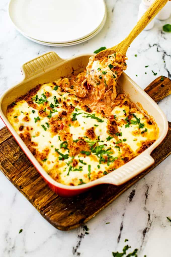 Photo of a cheesy spoon being pulled from Keto Chicken Parmesan Casserole.