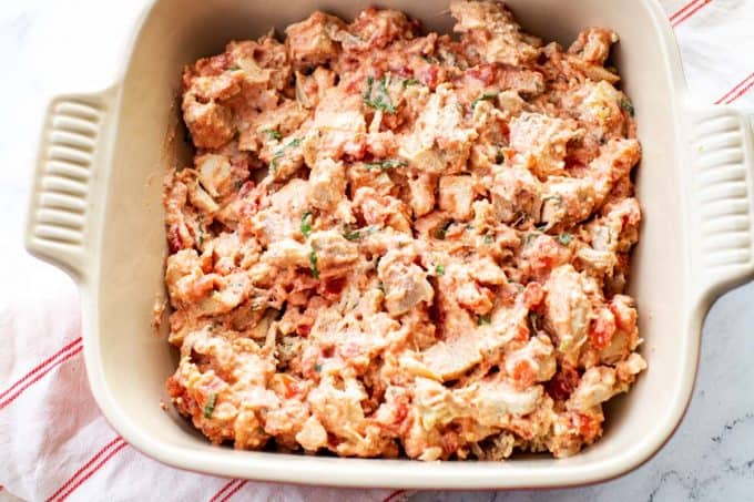 Photo of chicken, ricotta cheese, and tomato sauce in a casserole dish.