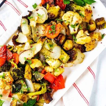 Overhead photo of Keto Roasted Vegetables on a white platter garnished with parsely.