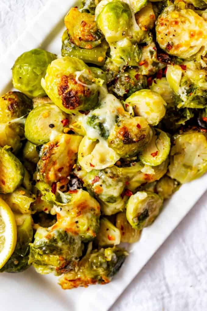 Photo of a white platter full of cheesy Instant Pot Brussels Sprouts.
