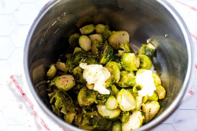 Photo of butter and lemon zest on top of cooked Brussels sprouts in an Instant Pot.