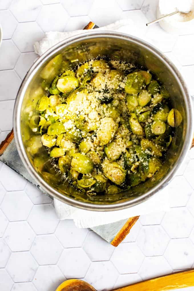 Photo of an Instant Pot with cooked Brussels Sprouts sprinkled with cheese.