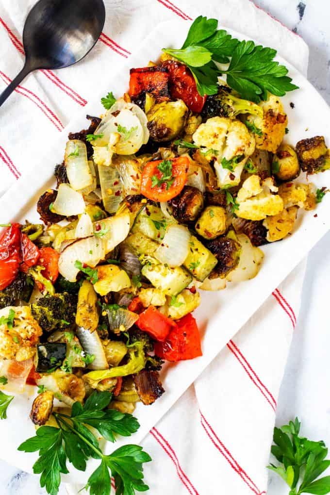 Overhead photo of Keto Roasted Vegetables on a white platter garnished with parsely.