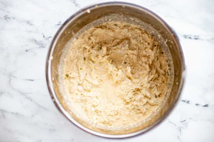 Photo of shredded chicken that has been added to a creamy cheese sauce.