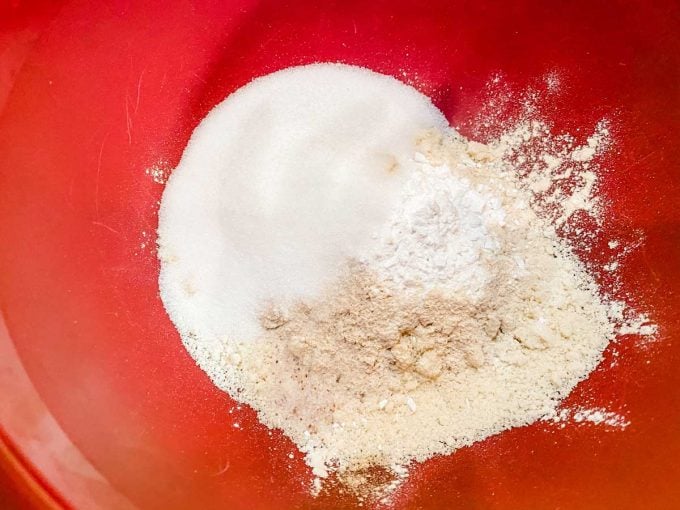 Flour, sweetener, oat fiber, baking powder, pumpkin pie spice, and salt in a large red bowl.