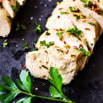 Close up photo of sliced keto turkey tenderloin garnished with parsley.