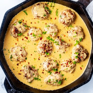 Square overhead photo of a cast iron skillet with keto Swedish Meatballs.
