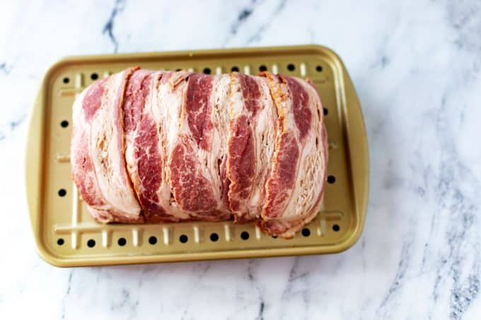 Photo of an uncooked bacon wrapped jalapeno popper meatloaf.