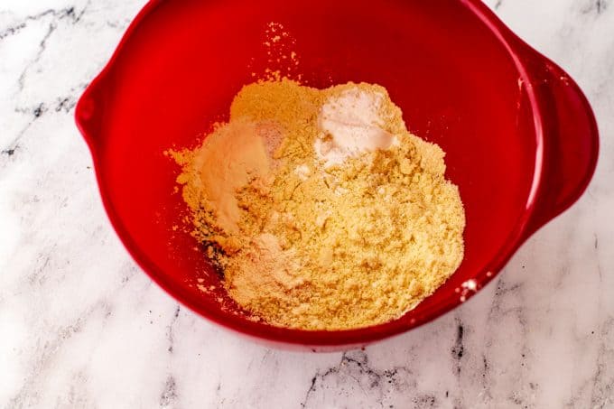 Red bowl with almond flour, oat fiber, baking powder, xanthan gum, and salt.
