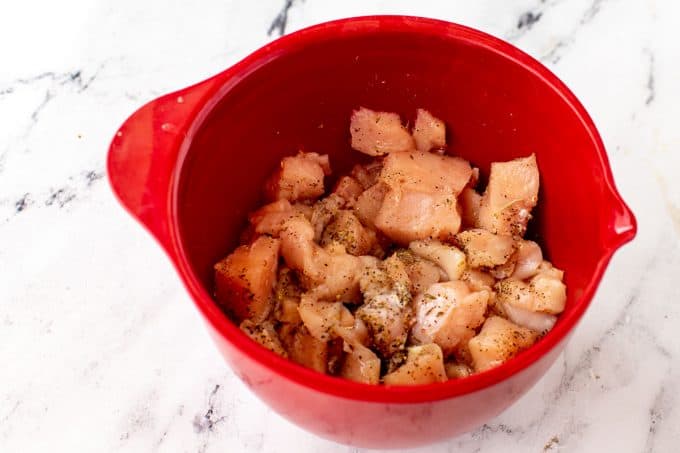 Photo of chopped chicken in a red bowl with seasonings.