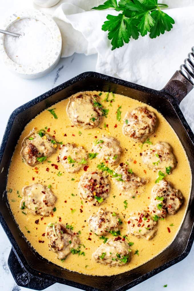 Overhead photo of a cast iron skillet with keto Swedish Meatballs.