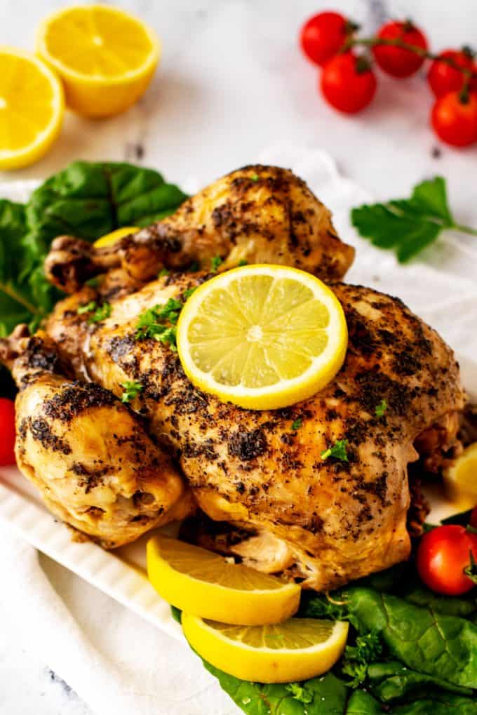 Close up photo of an Instant Pot Frozen Whole Chicken garnished with lemon.