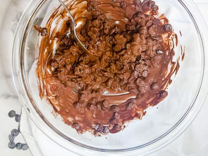 Photo of a glass bowl with chocolate chips and coconut oil that are starting to melt.