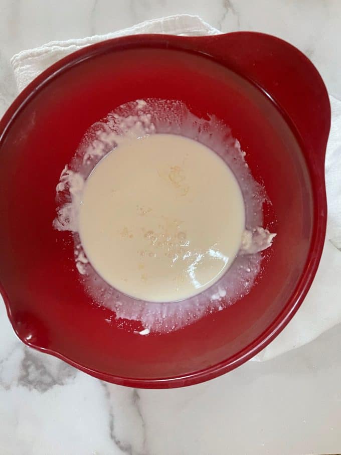 Photo of a red bowl with heavy cream and vinegar.