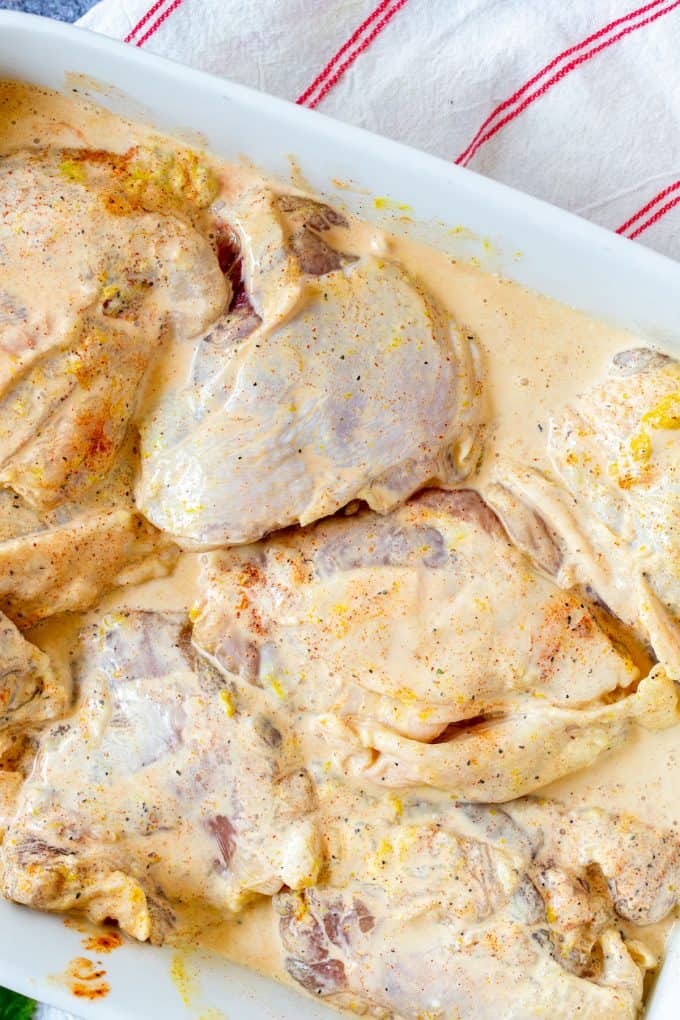 Photo of a shallow dish with chicken thighs marinating in it.