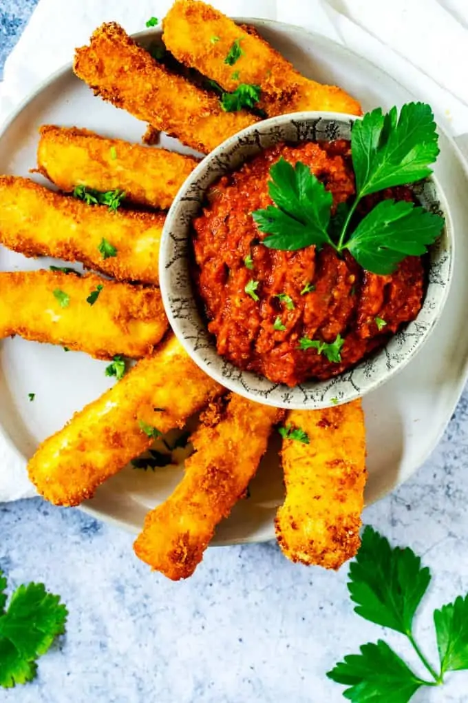 Plate of Keto Halloumi Fries with Marinara garnished with parsley.