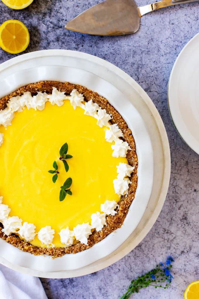 Overhead photo of a Keto Lemon Pie garnished with whipped cream and fresh mint.