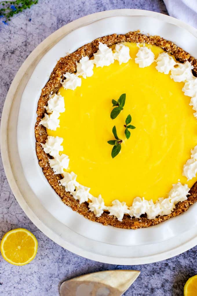 Photo of a keto lemon pie in a white pie plate.